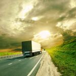 total truck support services truck - A large white truck drives down a highway on a sunny day with dramatic clouds overhead.